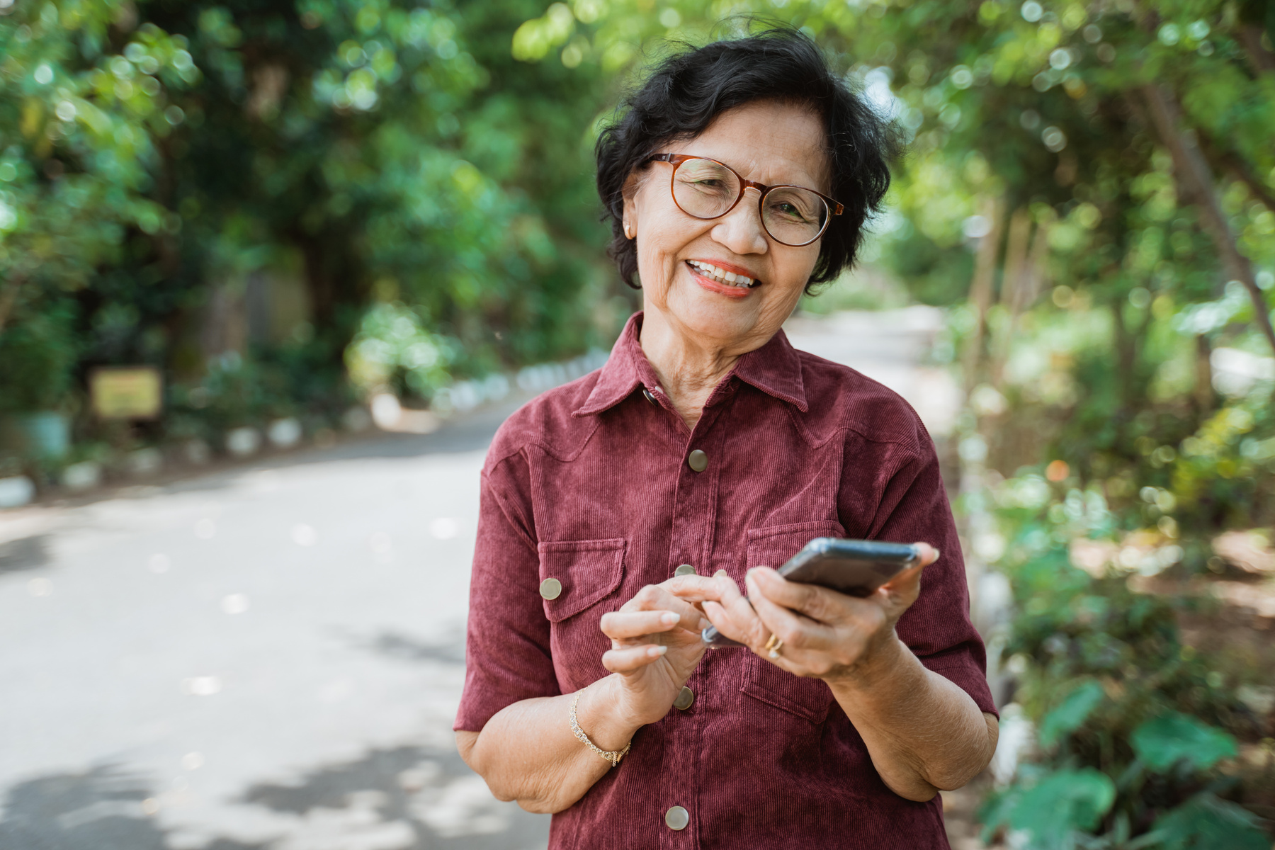 Smiling Asian Old Woman Using a Cell Phone